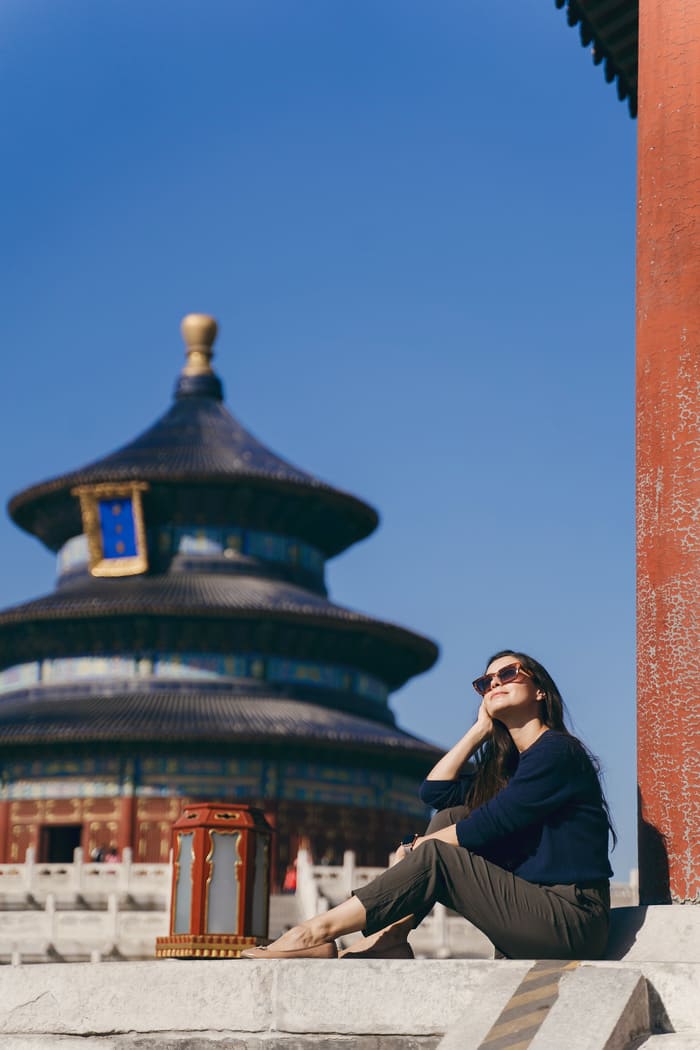 Turista contemplando el Templo del Cielo en Beijing bajo un cielo despejado.
